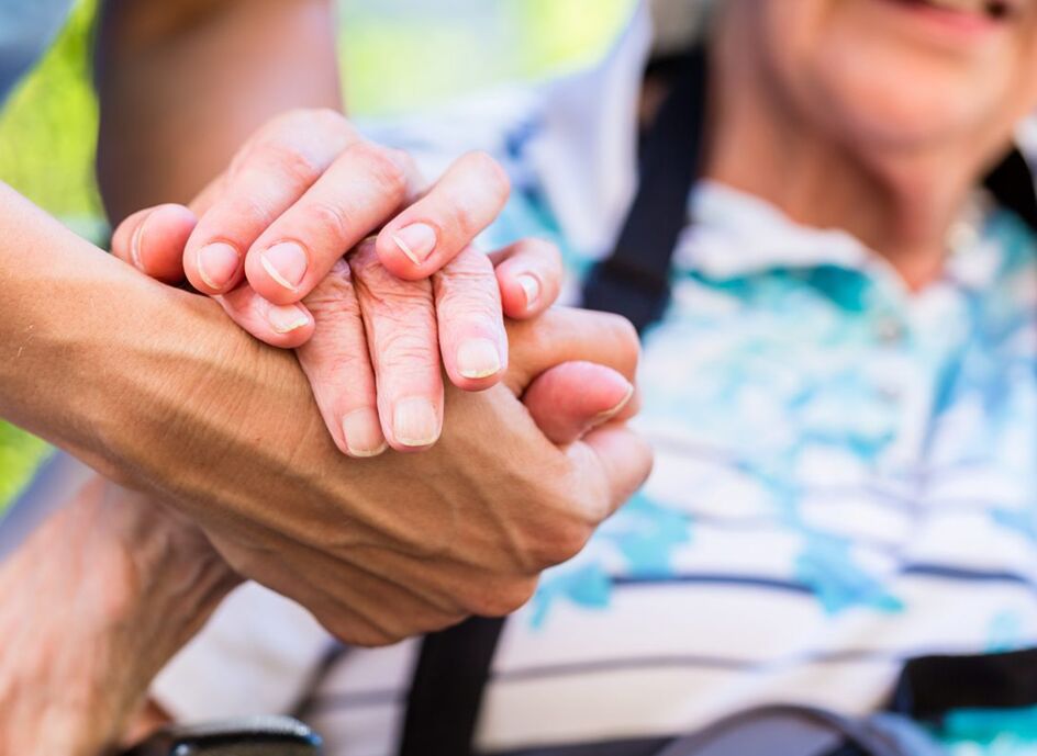 Pflegerin die Rentnerin die Hand reicht